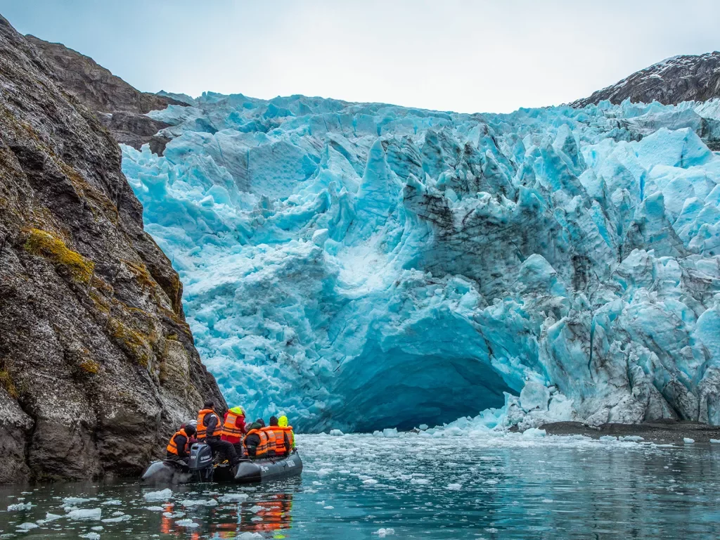 Guests on raft, floating towards blue glacier.