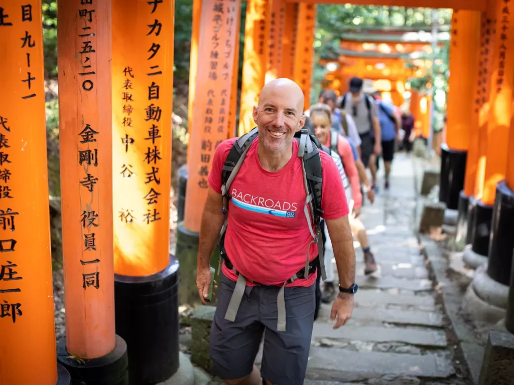 Walking up a hill among orange arches in Japan