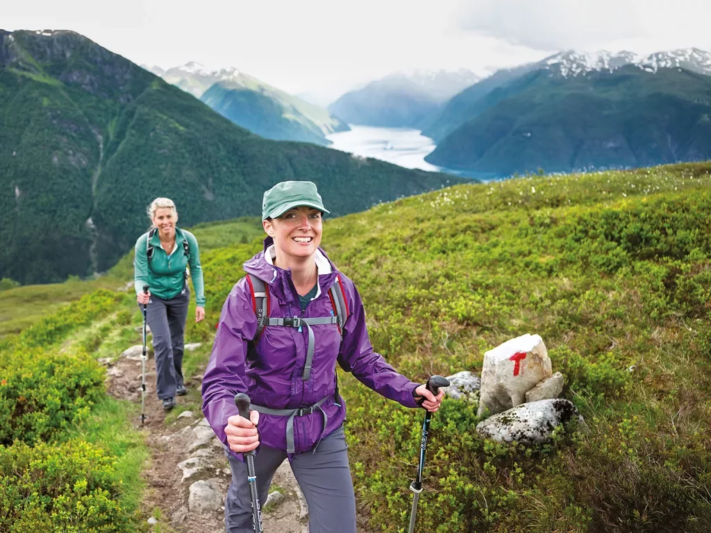 Two women hiking on a mountainous landscape.