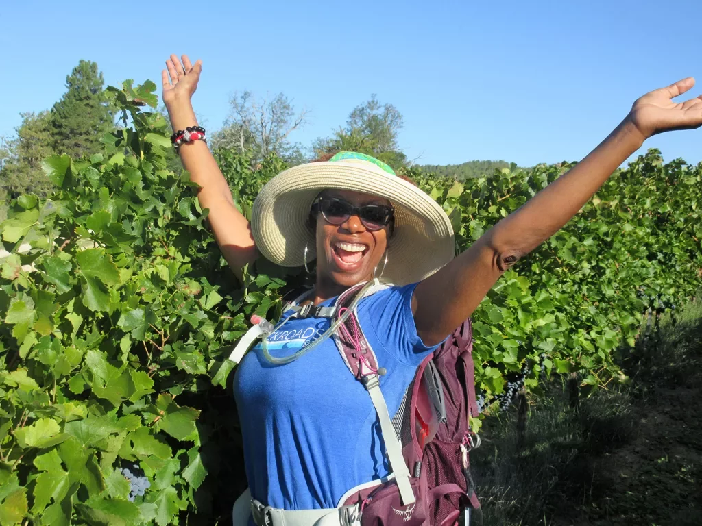 Backroads Guest in Front of Grape Vines with Hands in the Air 