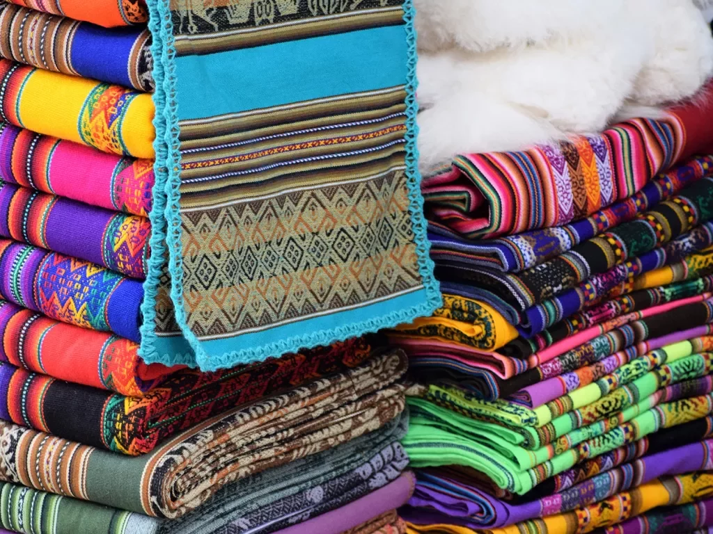 Colorful pile of textiles, numerous different patterns and colors.