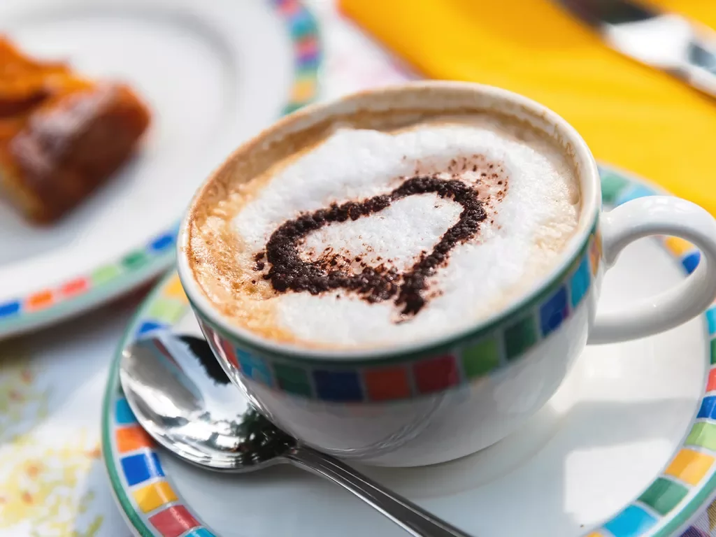 Close up of coffee cup, decorated with sugar heart.