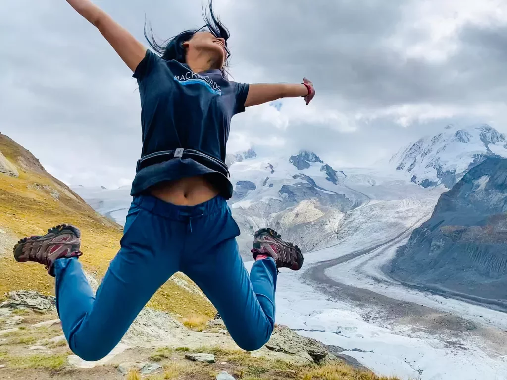 Woman posing for camera, jumping into air.