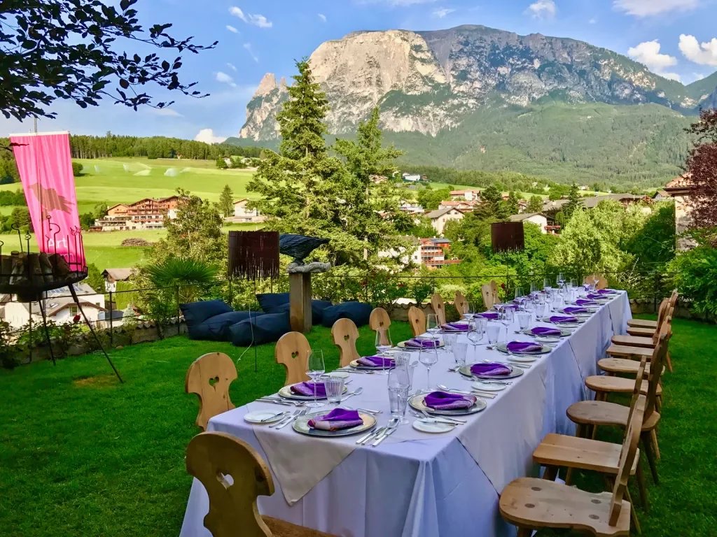 Long outdoor dining table set for a meal amid the Dolomites