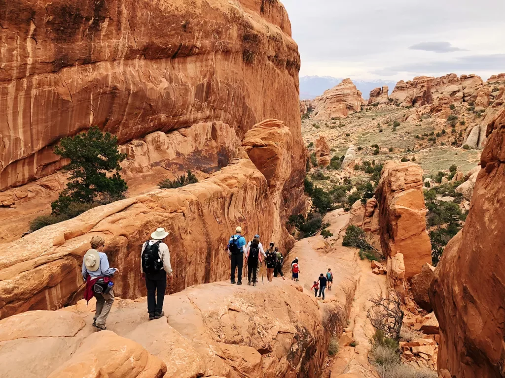 Guests hiking in national park among boulder formations