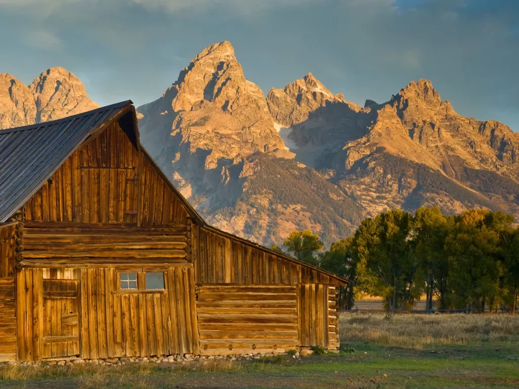 Wooden cabin with rocky mountains in background