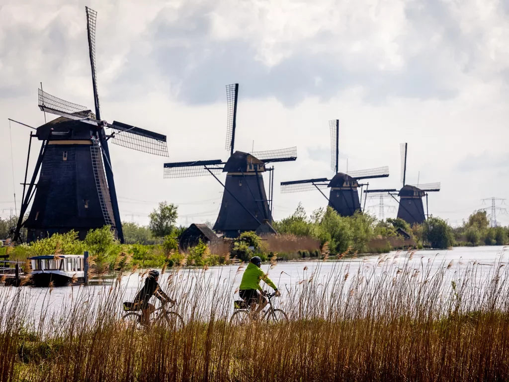 Two bikers in front of windmills