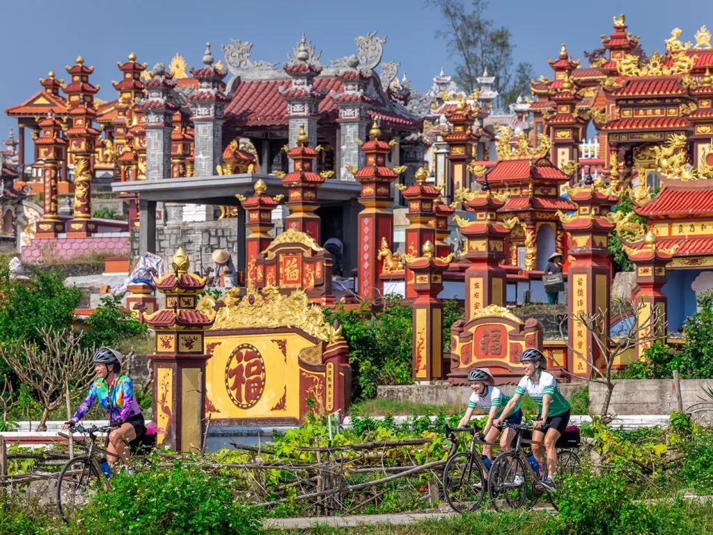 Bikers cycling through red and yellow temples