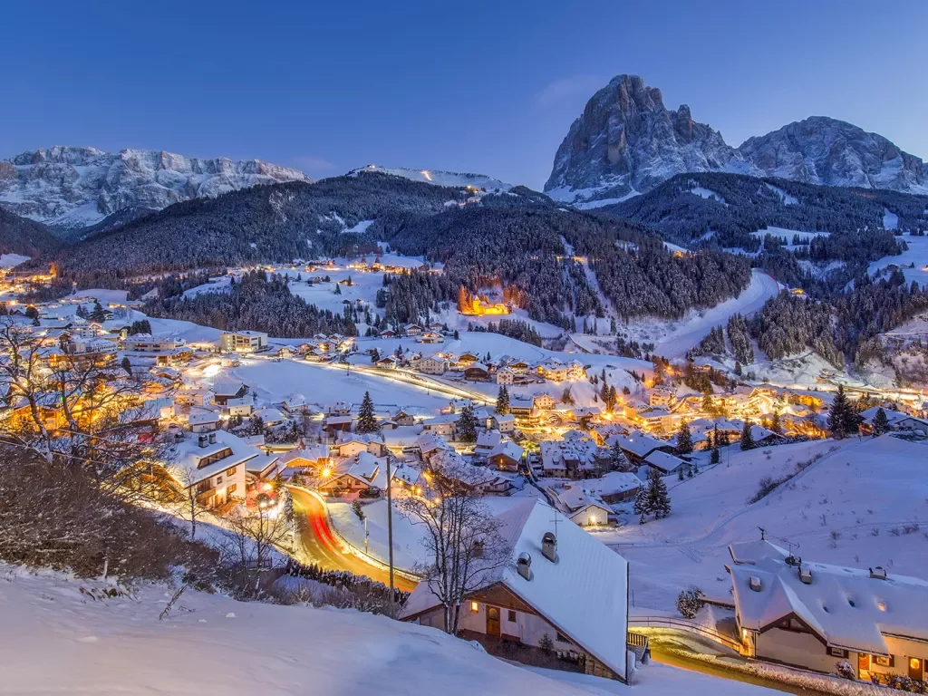 A small town covered in snow and lit up with lights