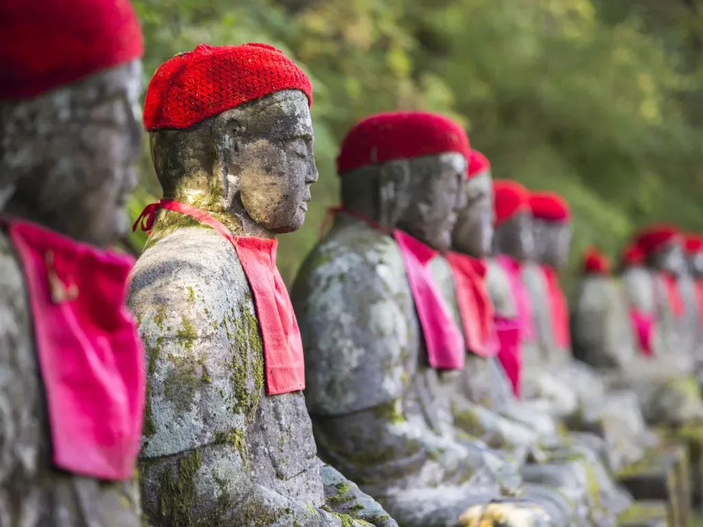 stone statues wearing red hats