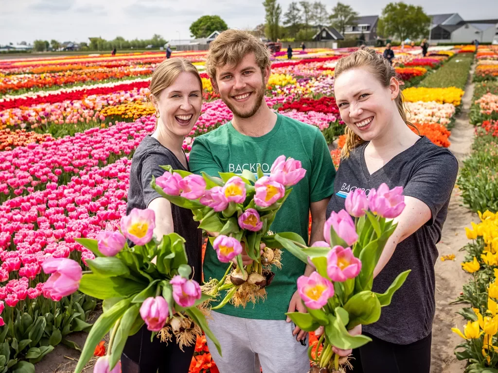 A man and two women in a field of flowers
