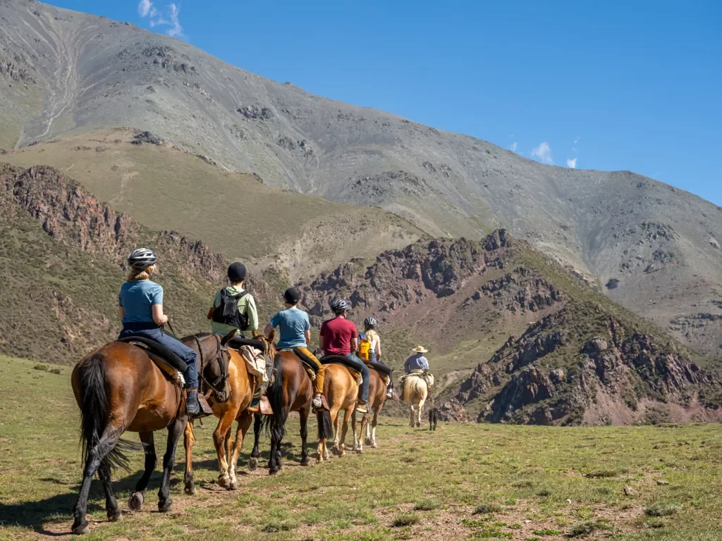 people horseback riding in the mountains