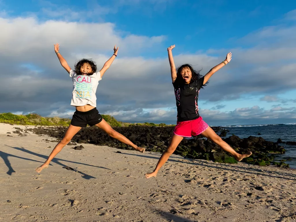 Two girls jumping on a beach