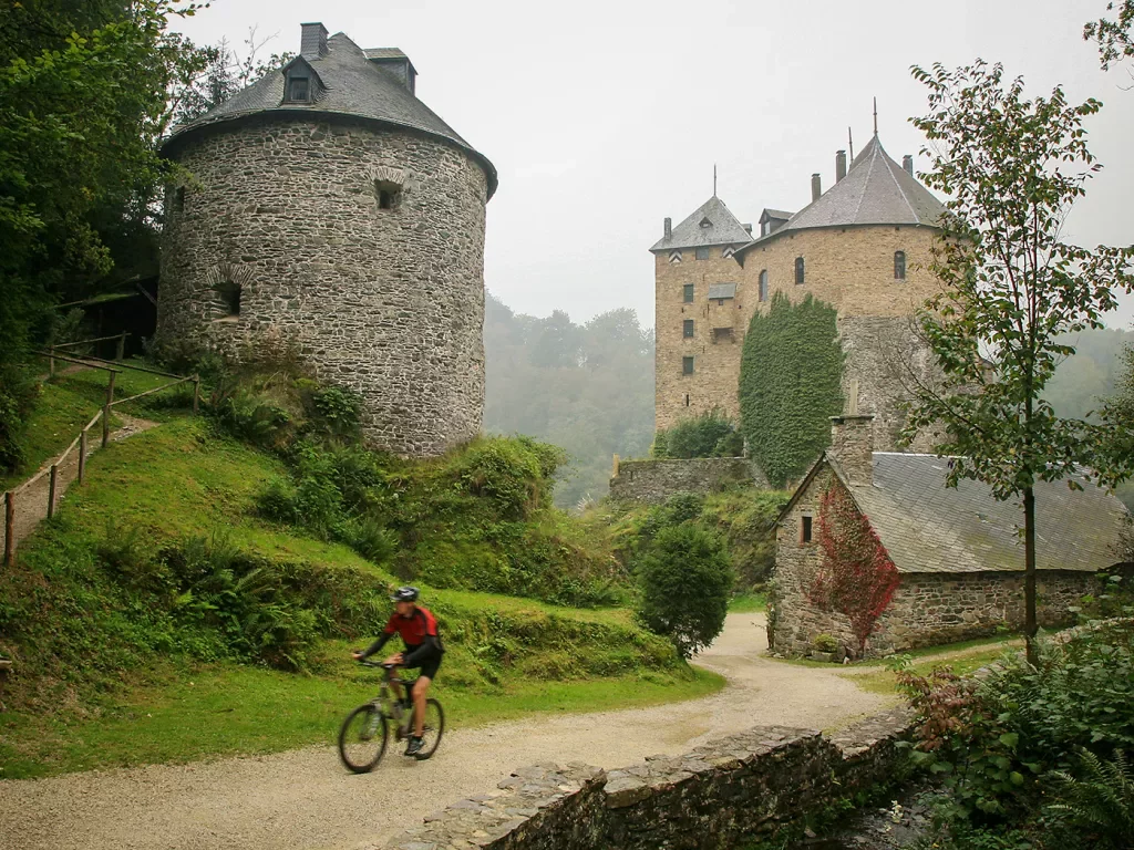 Stone towers and a man biking through the gravel trail