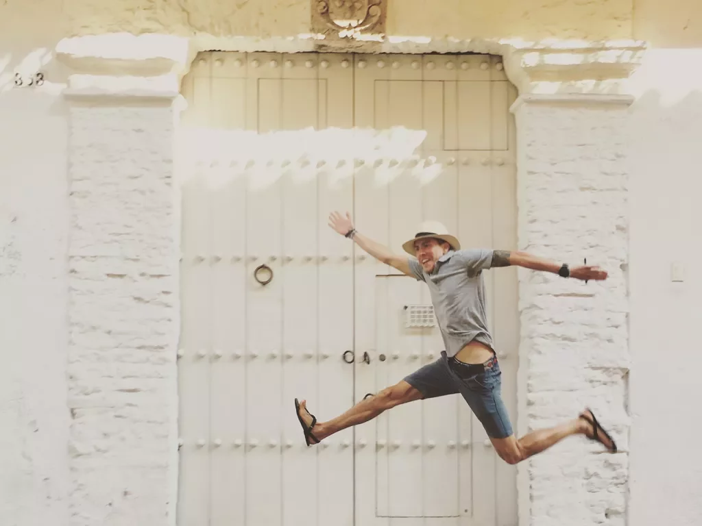 A man jumps in front of a white wall