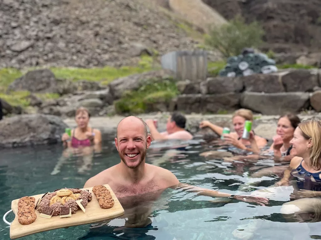 Man in a pool holding a cutting board full of cookies