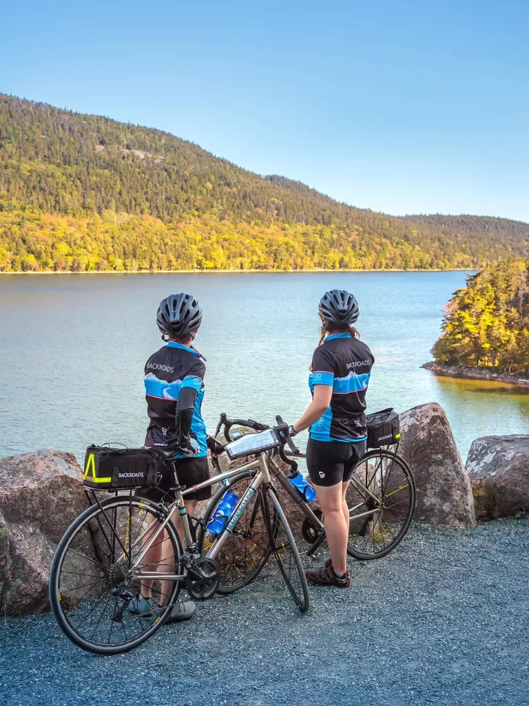 Two guests with bikes overlooking large body of water.
