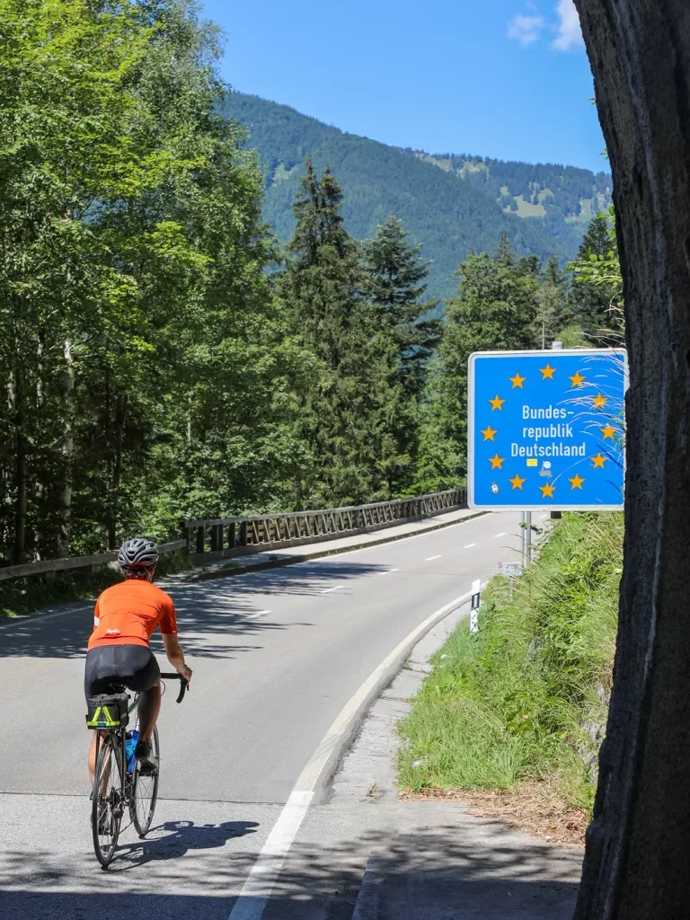 Biker riding past sign that reads "Bundes-republik Deutschland"