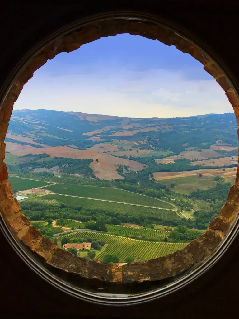 Circular window overlooking Italian countryside. 