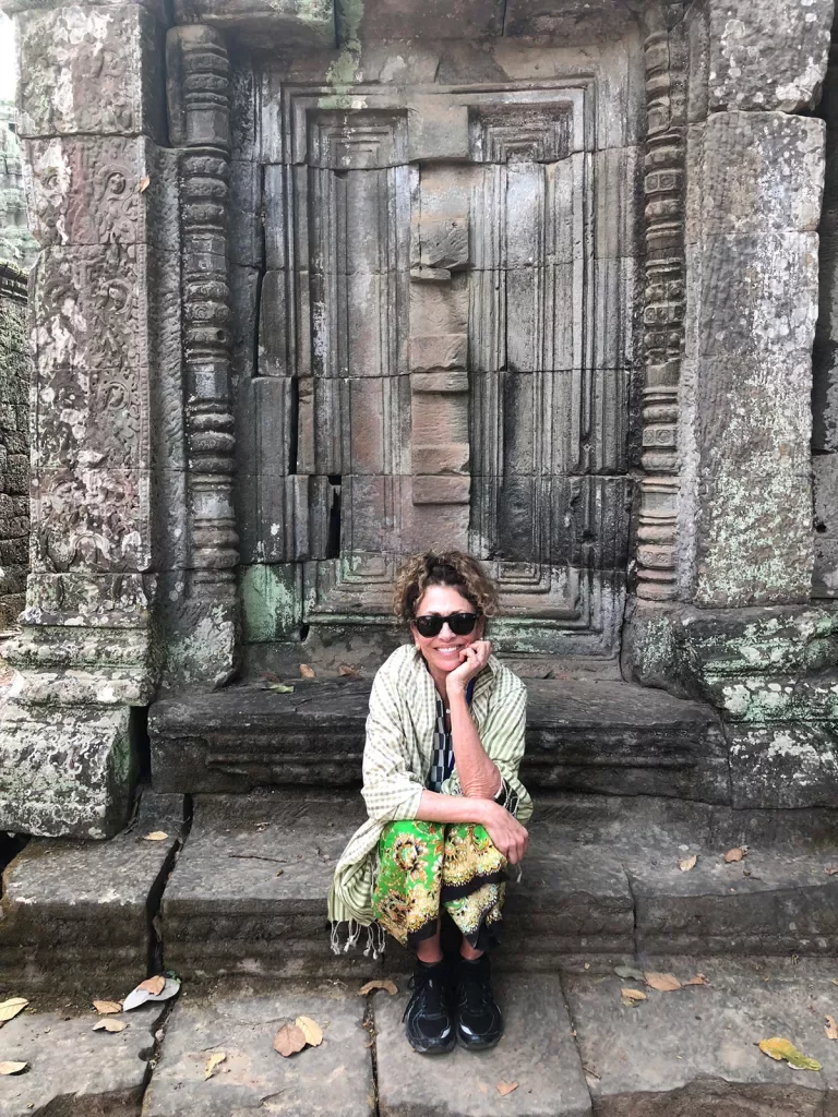 Woman sitting on a stone step in Angkor Wat in Cambodia