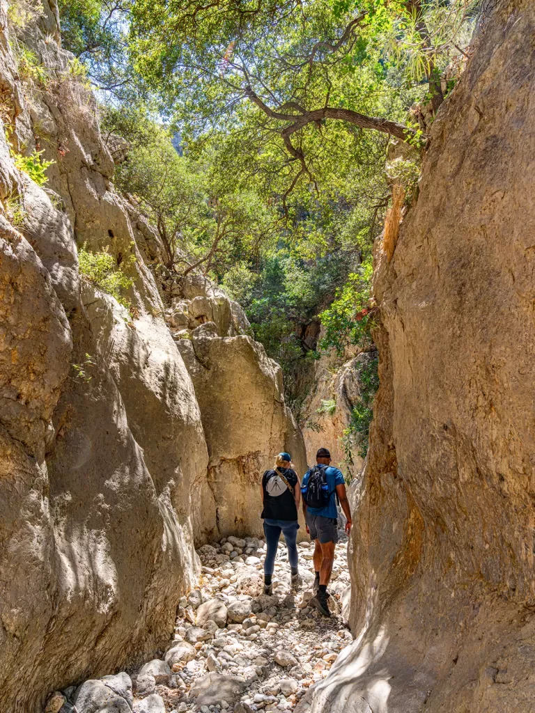 Two guests walking between large cliffs.