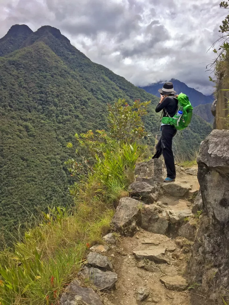 Backroads guest pausing on a hike to photograph mountain in Peru.