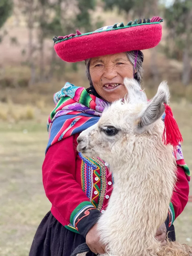 Local woman in colorful garb, baby alpaca.