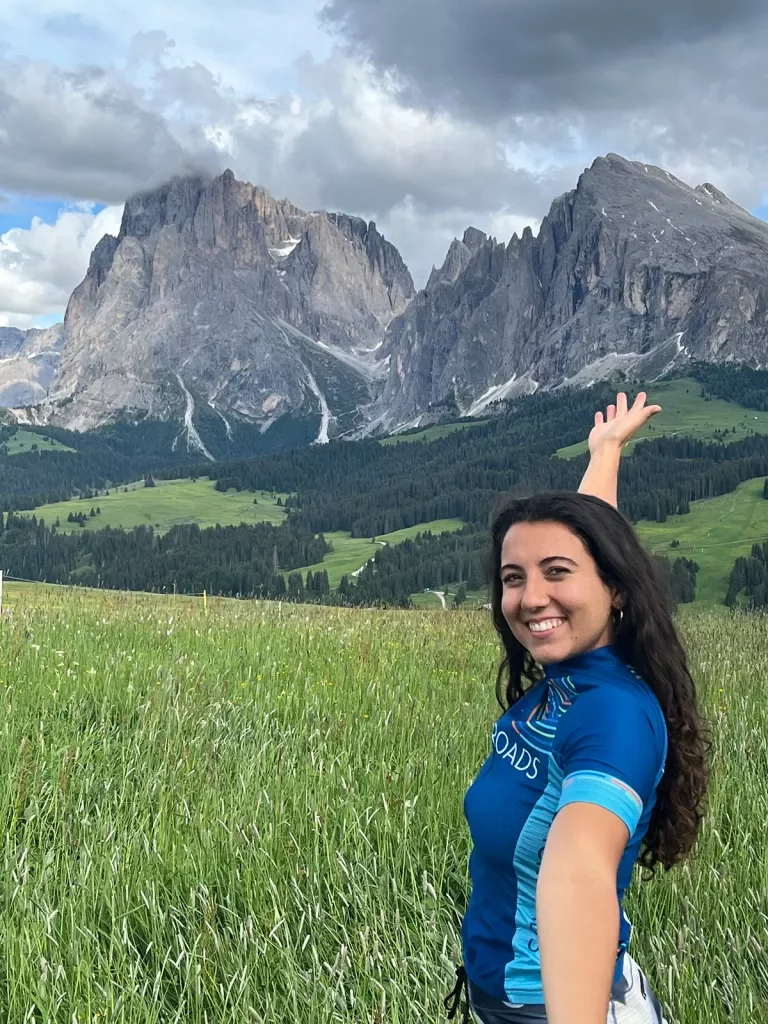 Young guest taking selfie, gesturing to large mountain range in distance.