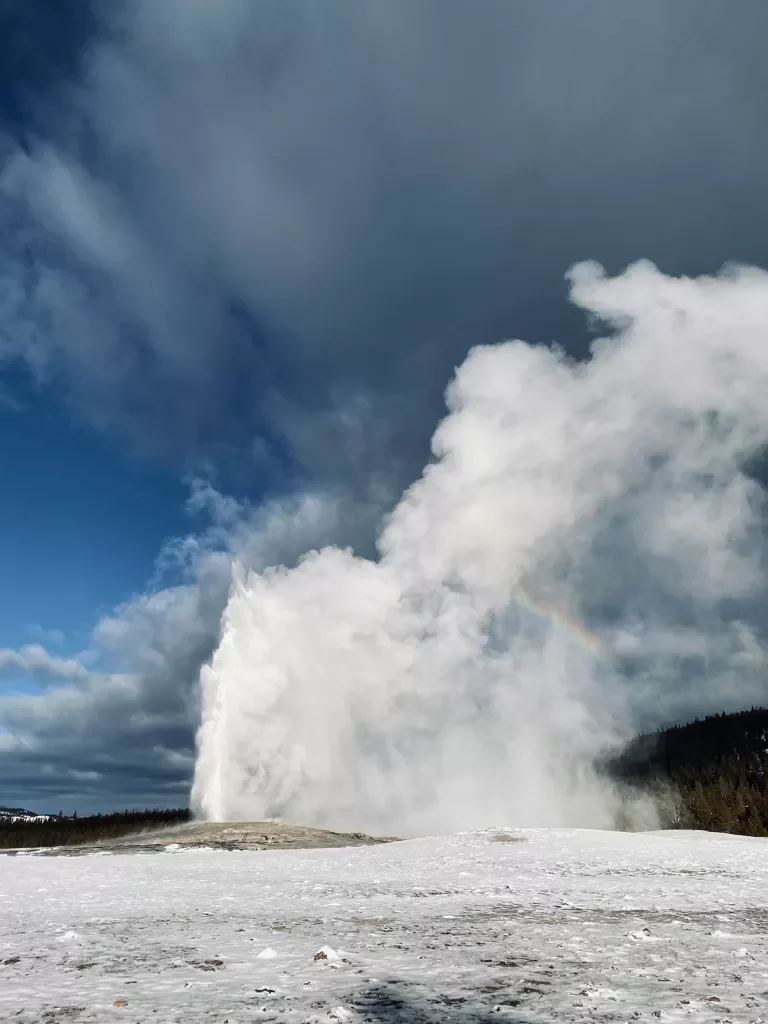 Geyser erupting on a snowy landscape