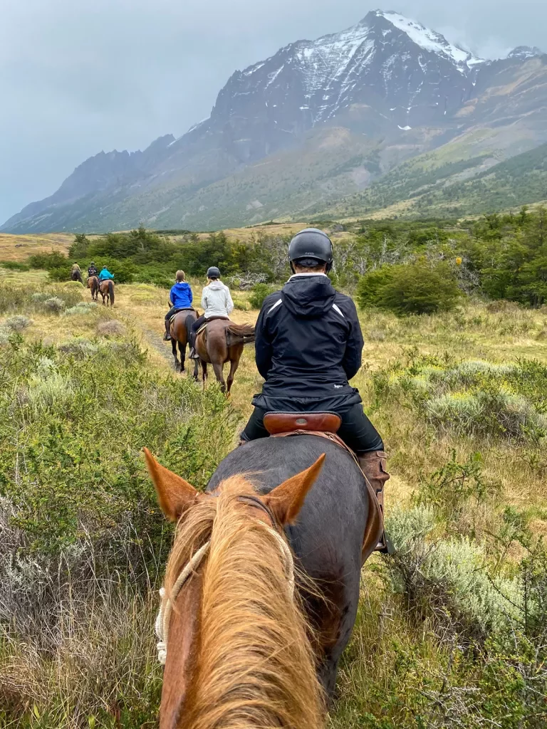 Point of view shot of guests on horseback, heading towards ring of mountains.