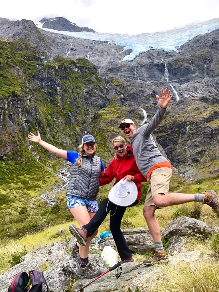 Guests excitedly posing on a rock in New Zealand