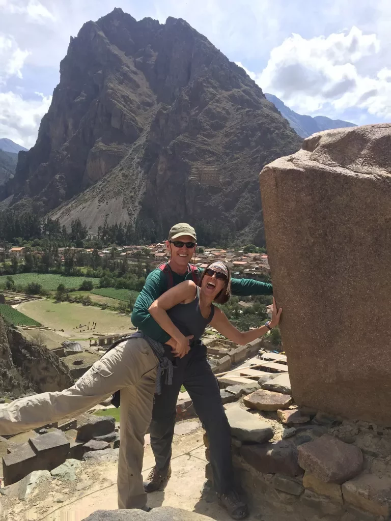 Two guests embracing playfully, large mountain in background.