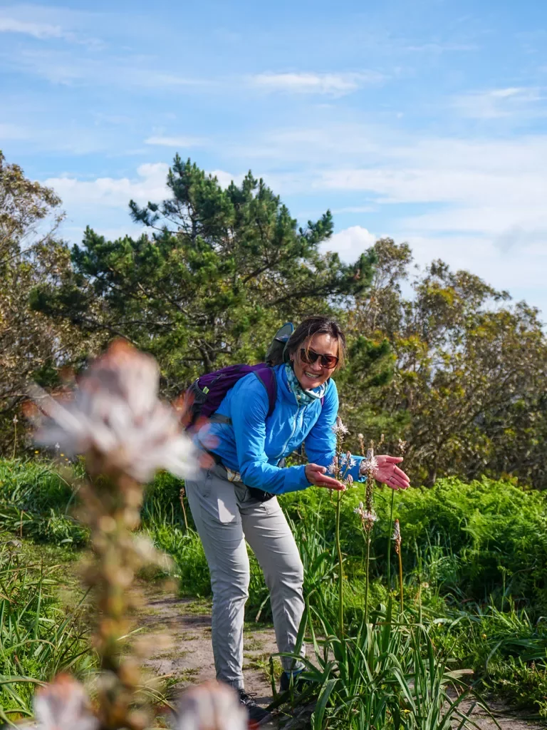 A hiker appreciating flowers