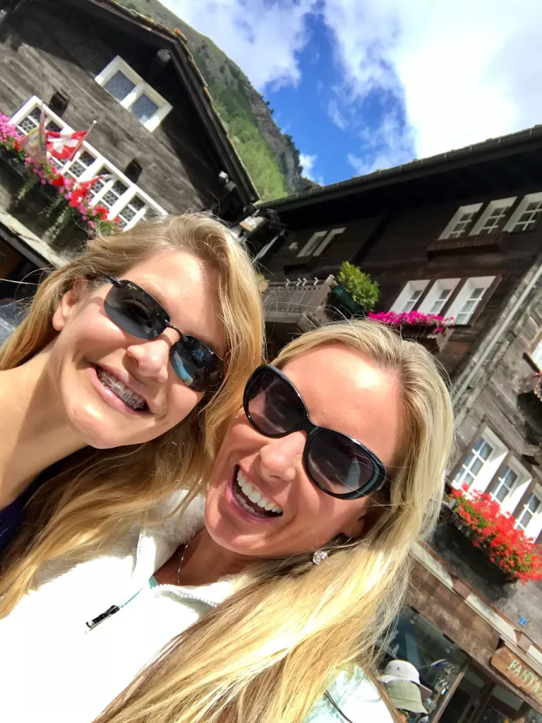 Two guests taking selfie, German style wooden buildings behind them.