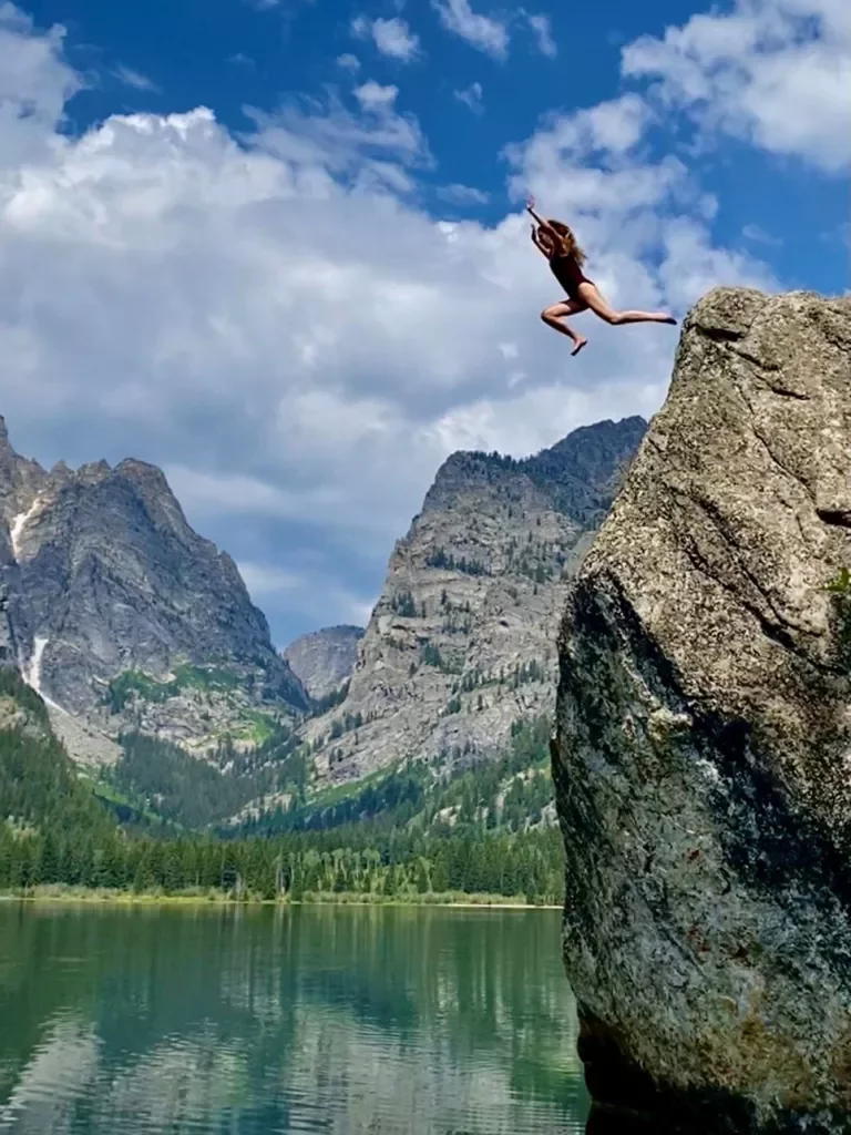 Backroads guest cliff jumping into refreshing lake