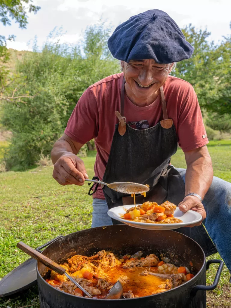 Person serving stew from a large pot