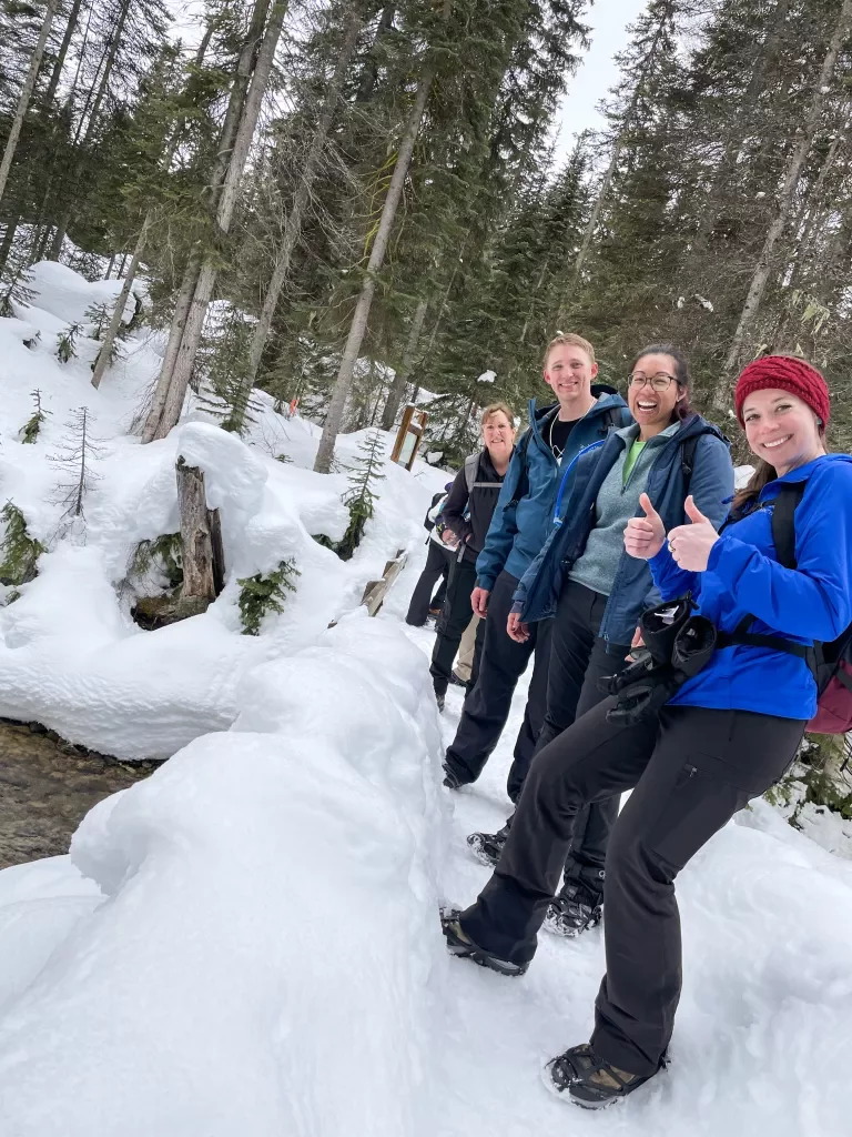A group of hikers pose on a snowing hike