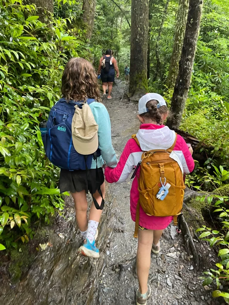 Two kids with backpacks on a hike