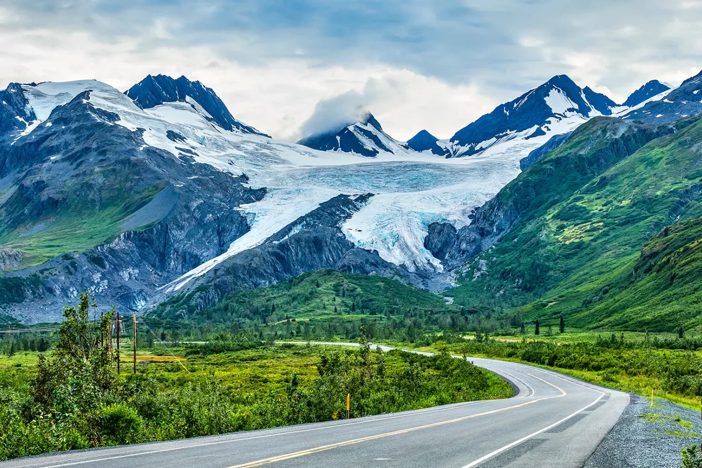 Winding road leading to snow covered mountains in Alaska