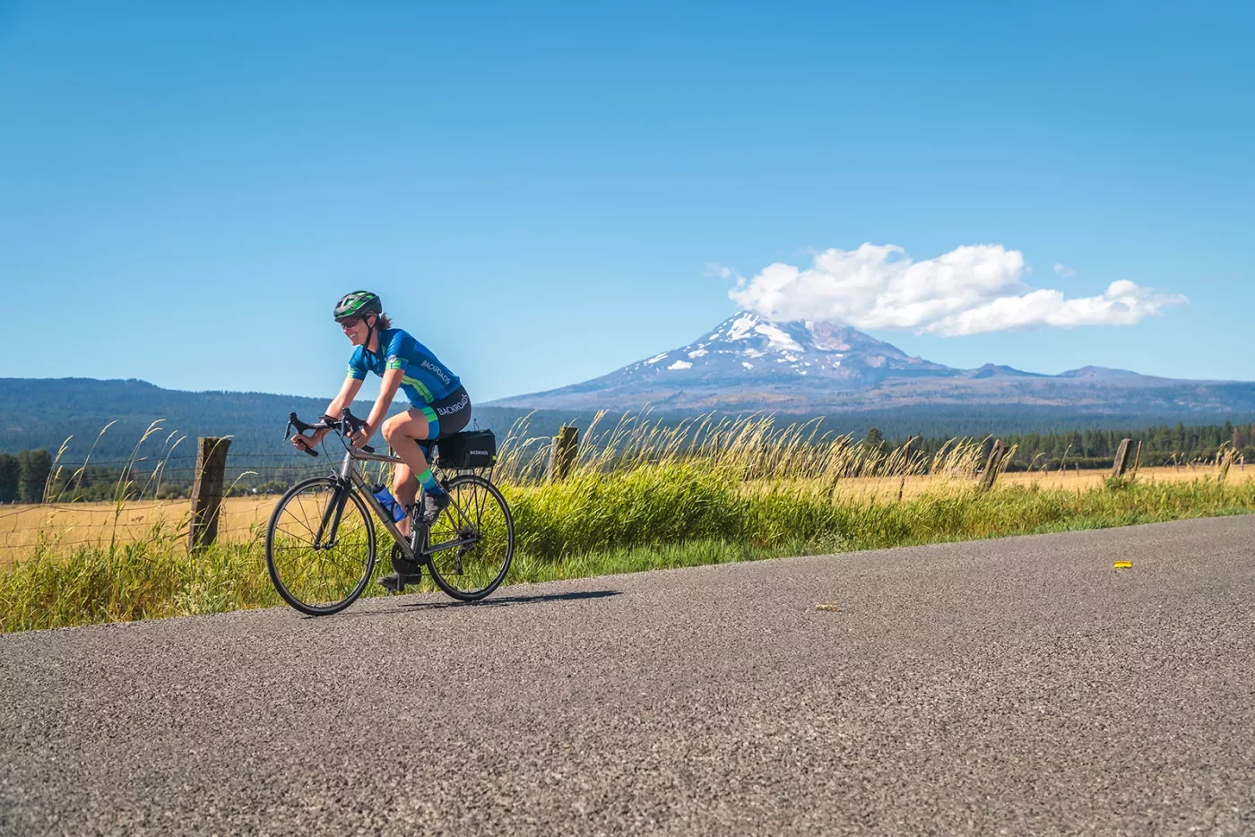 Guest riding down grassy road, Mount Hood in background.