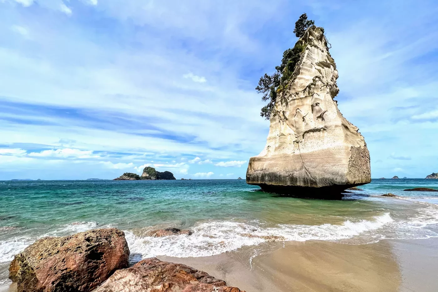 Tall rock formation by the beach in New Zealand