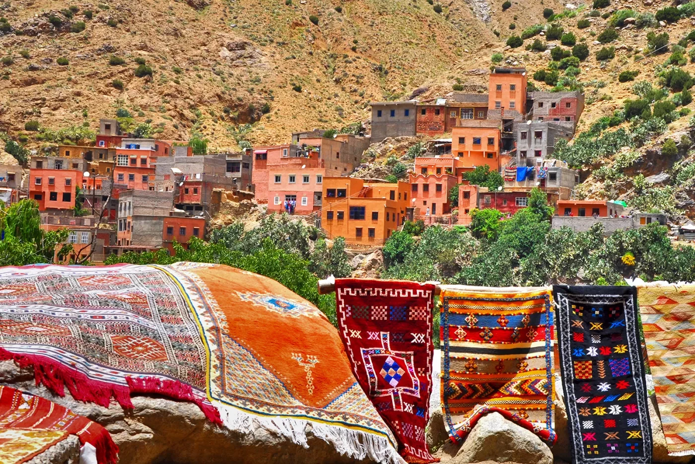 Shot of vibrant desert valley town, tapestries in foreground.
